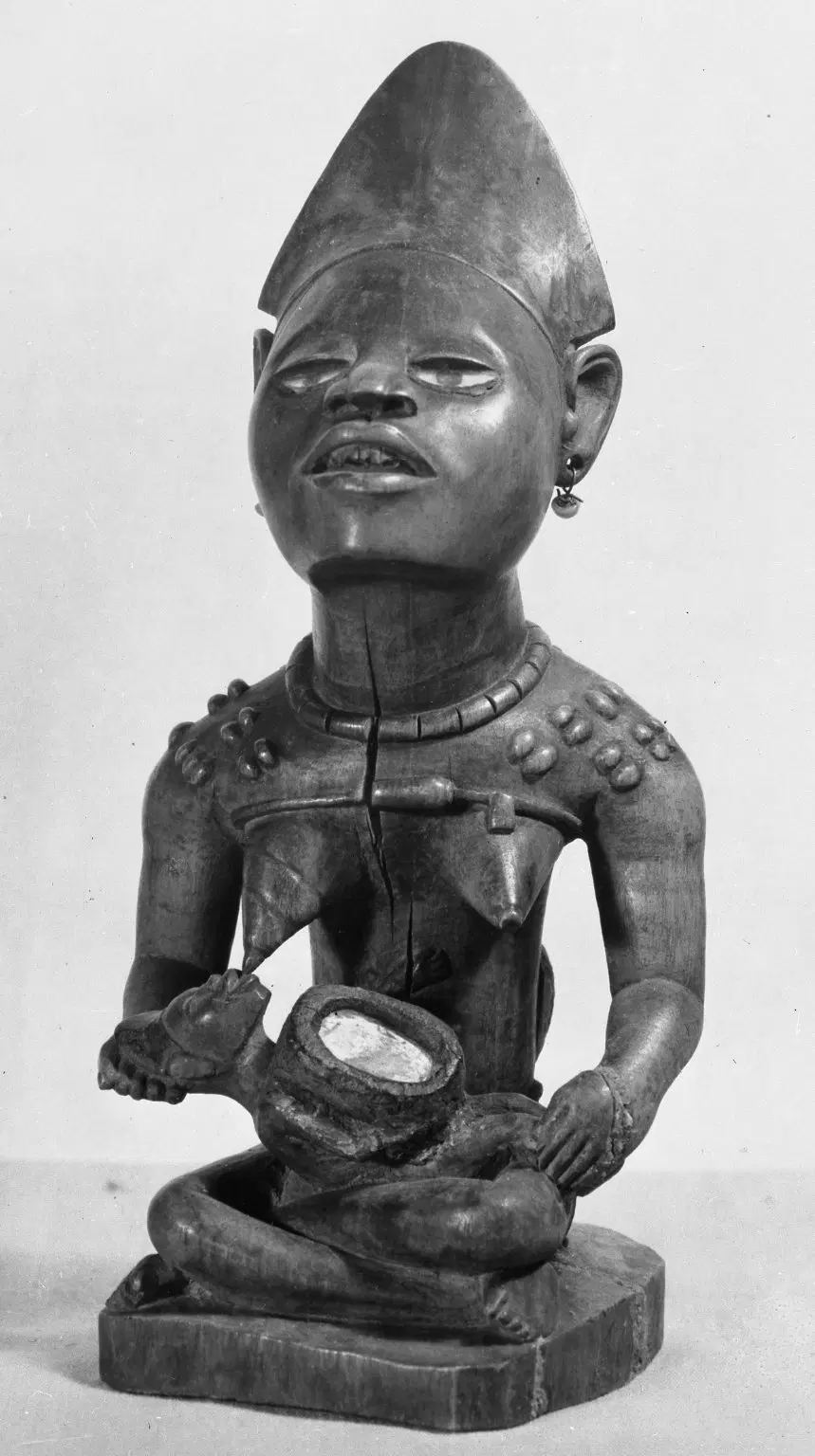 Carved wooden seated woman with child and head ornaments